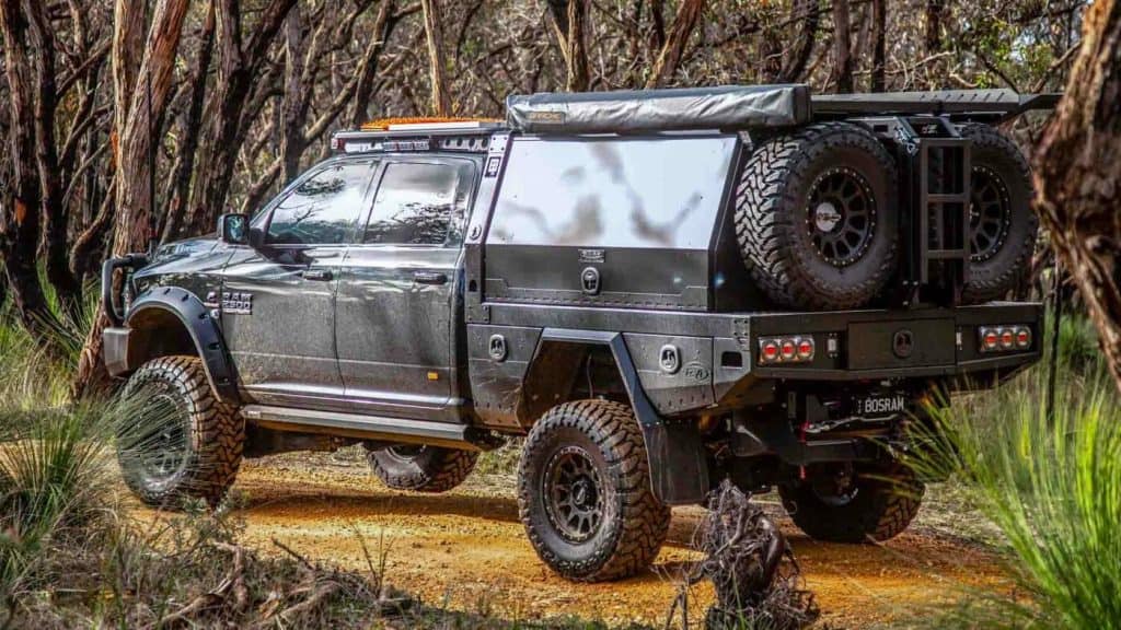a truck equipped with the best canopy trays parked in the middle of a forest.