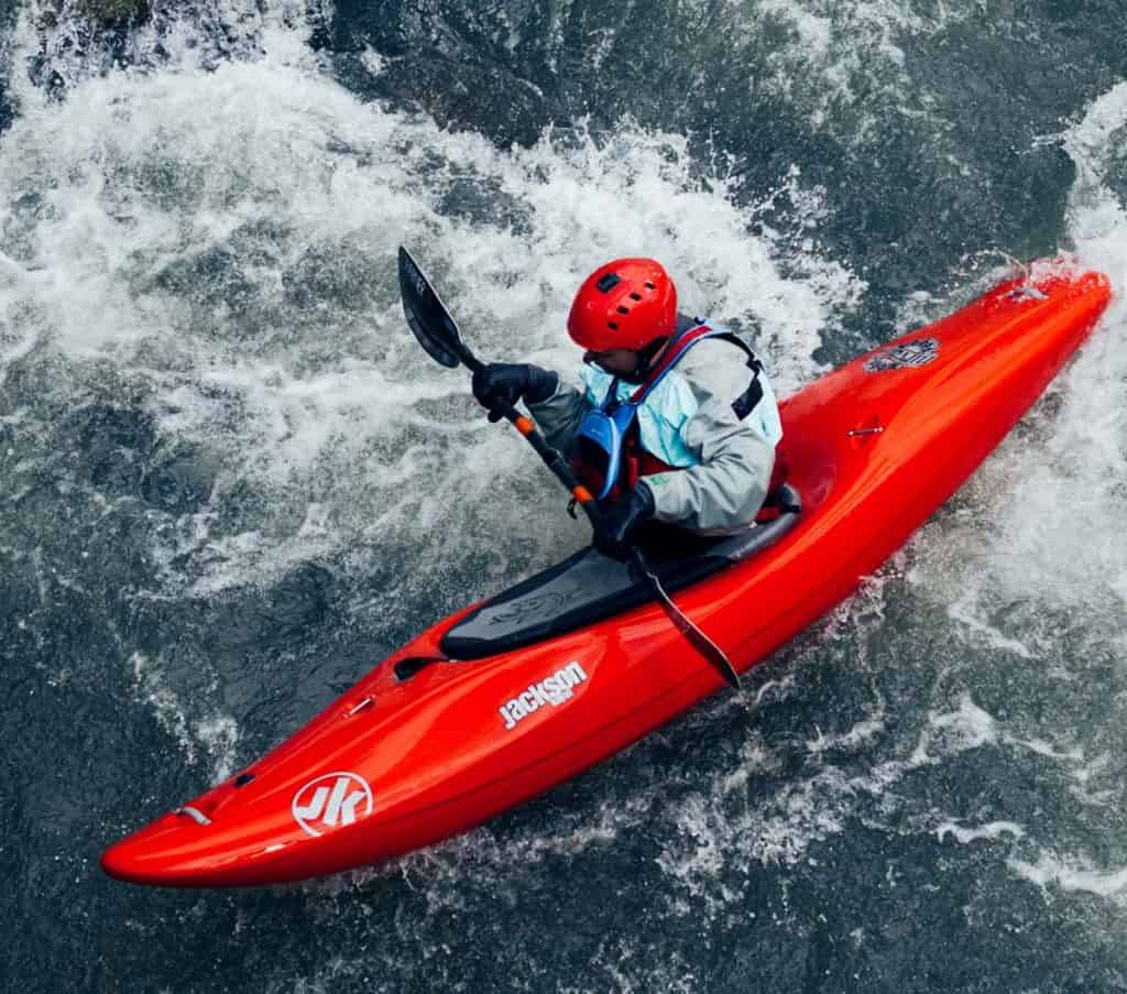 A man in a fishing kayak on the water.
