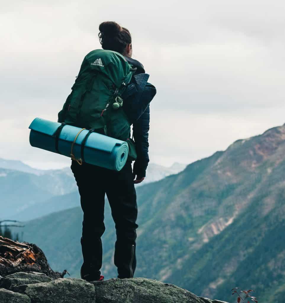 a person on a mountain with a camping mattress in blue tube.