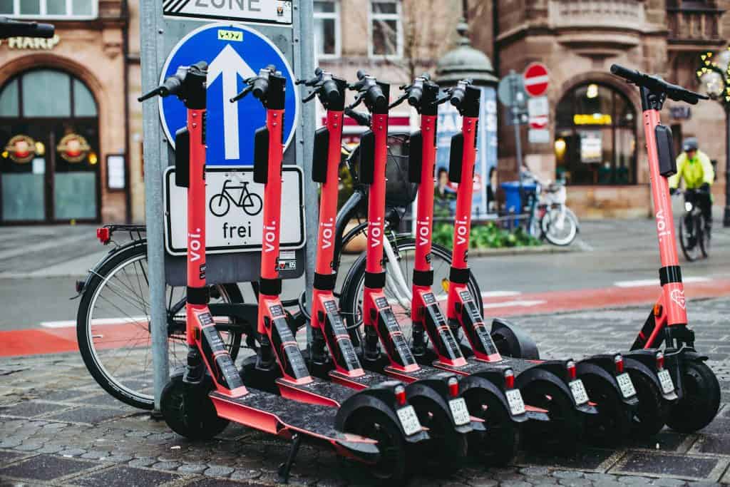 A group of the best e-scooters parked next to a street sign.